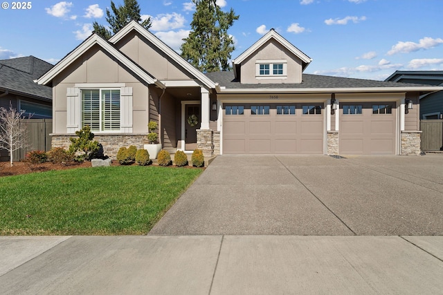 view of front facade with stucco siding, a front yard, fence, stone siding, and driveway