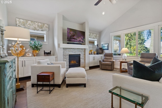 living room with ceiling fan, a stone fireplace, light wood-type flooring, high vaulted ceiling, and recessed lighting