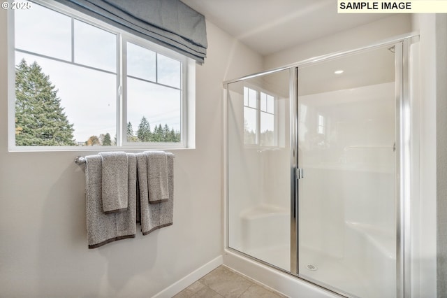 full bath featuring a stall shower, baseboards, and tile patterned floors