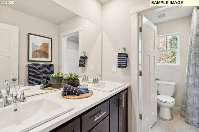 full bath featuring toilet, double vanity, and tile patterned floors