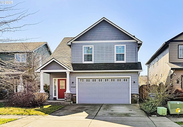 view of front facade featuring a garage, driveway, a shingled roof, and stone siding