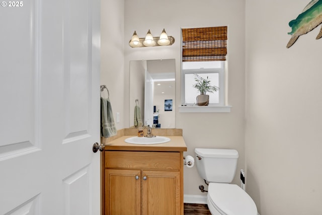 bathroom with vanity, toilet, and baseboards