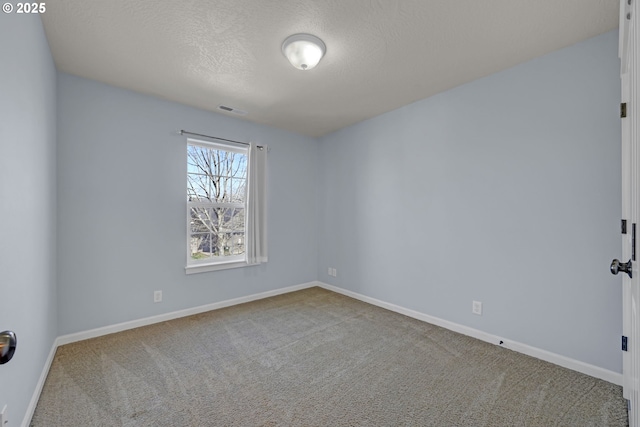 unfurnished room with carpet floors, visible vents, a textured ceiling, and baseboards