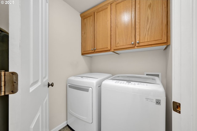 laundry room with washing machine and dryer, cabinet space, and baseboards