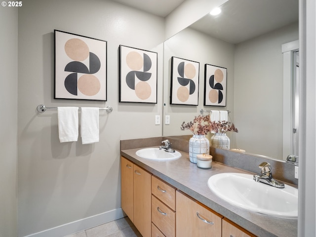 full bathroom with tile patterned flooring, a sink, baseboards, and double vanity