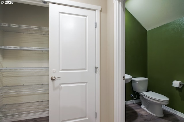 bathroom featuring lofted ceiling and toilet