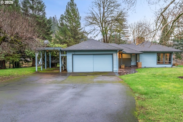 ranch-style home with a garage, a chimney, a front yard, and aphalt driveway