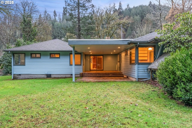 rear view of property with a yard, covered porch, and a carport