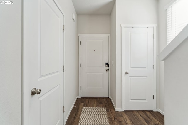 hall with dark wood-style floors and baseboards