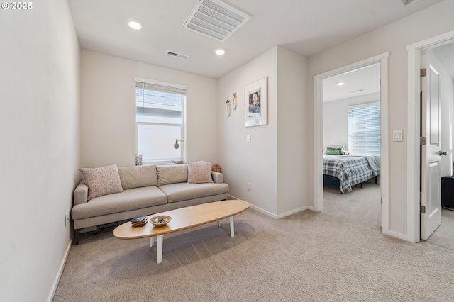 carpeted living area with recessed lighting, visible vents, and baseboards