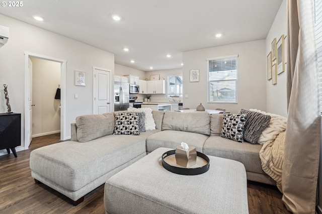 living room featuring dark wood-type flooring, recessed lighting, baseboards, and a wall mounted AC