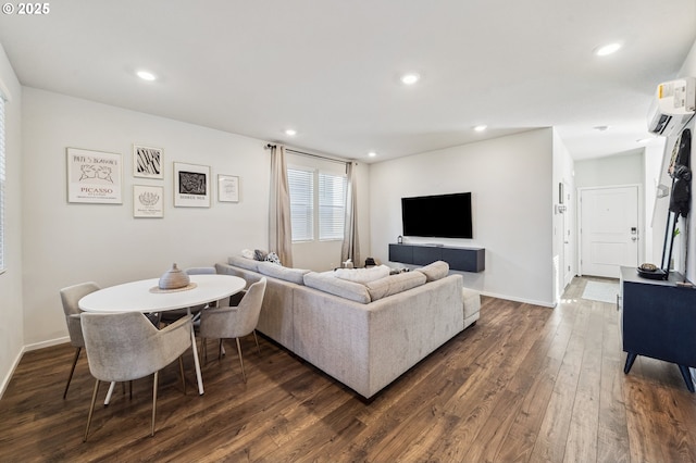 living room featuring recessed lighting, baseboards, dark wood finished floors, and a wall mounted AC