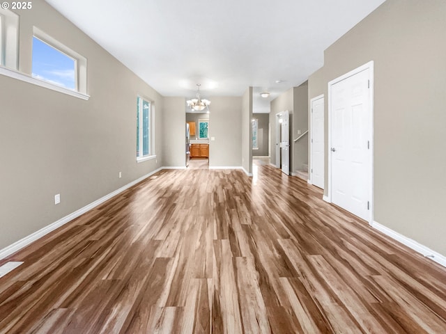 unfurnished living room with hardwood / wood-style flooring and a chandelier