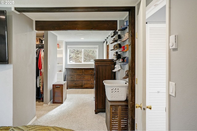 corridor featuring beam ceiling and carpet