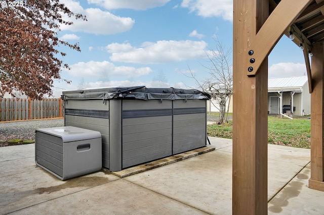 view of patio / terrace with a jacuzzi and fence