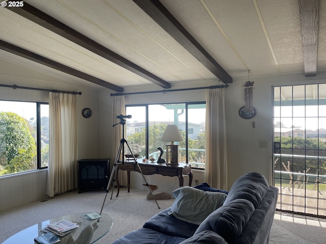 carpeted living room with a healthy amount of sunlight, a textured ceiling, and lofted ceiling with beams