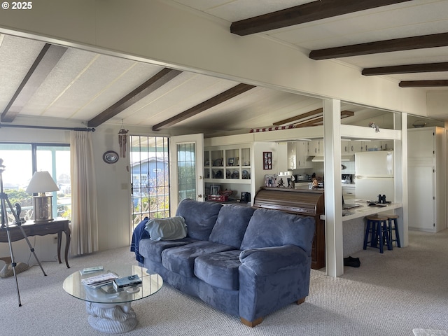 carpeted living room with lofted ceiling with beams