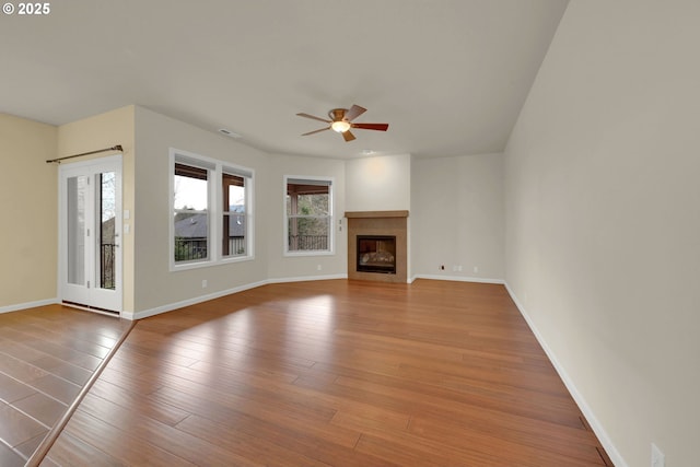 6018 Fernhill Loop, Springfield, OR 97478 - unfurnished living room with ceiling fan, baseboards, wood finished floors, and a glass covered fireplace