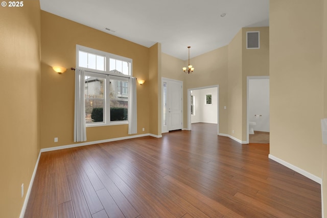 6018 Fernhill Loop, Springfield, OR 97478 - unfurnished living room featuring a chandelier, hardwood / wood-style flooring, baseboards, and a high ceiling