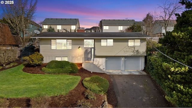 split foyer home with a yard, driveway, and a garage