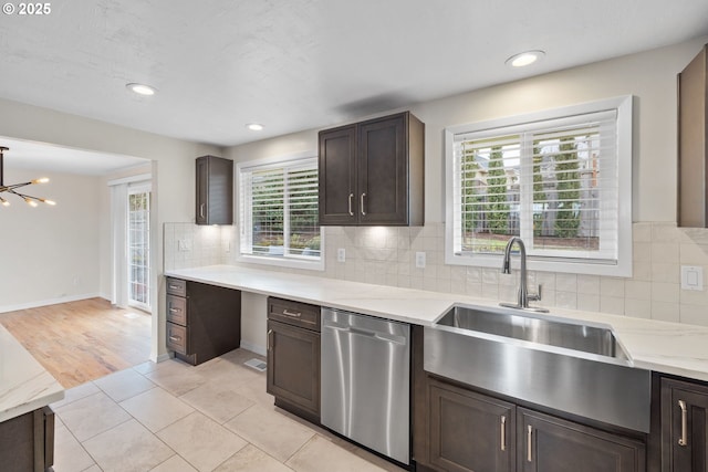 kitchen featuring a sink, dark brown cabinetry, backsplash, and stainless steel dishwasher