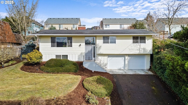 view of front of house featuring an attached garage, fence, driveway, a chimney, and a front yard