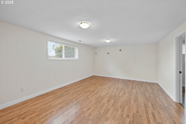 unfurnished room featuring light wood-type flooring, visible vents, and baseboards