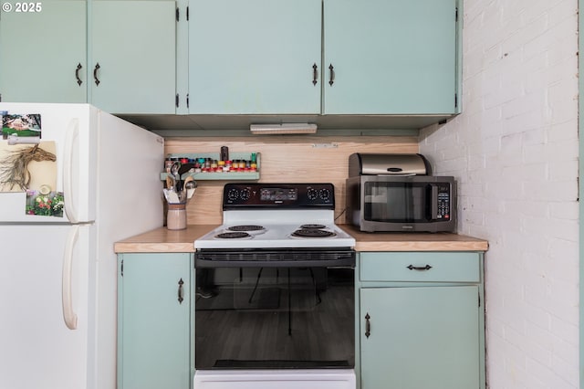 kitchen with range with electric cooktop, freestanding refrigerator, stainless steel microwave, and light countertops