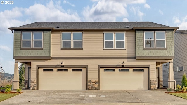 view of front of house with a garage, stone siding, and driveway