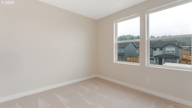 carpeted spare room with baseboards