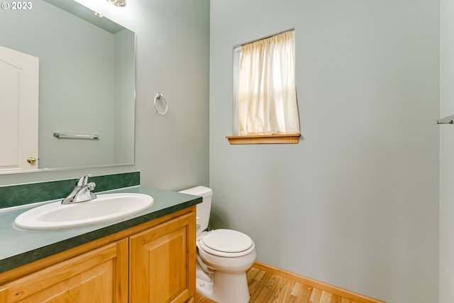 bathroom with hardwood / wood-style floors, toilet, and vanity