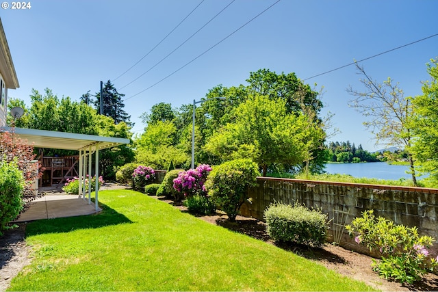 view of yard with a water view and a patio