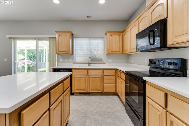 kitchen featuring light brown cabinetry, sink, and black appliances