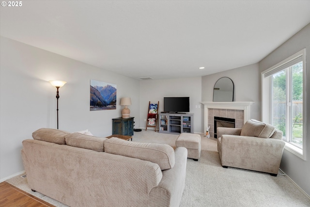 living area featuring recessed lighting, a tile fireplace, baseboards, and visible vents