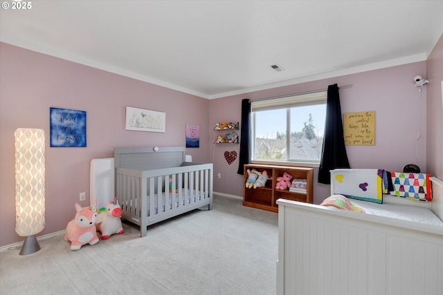 bedroom with baseboards, visible vents, a crib, and carpet floors