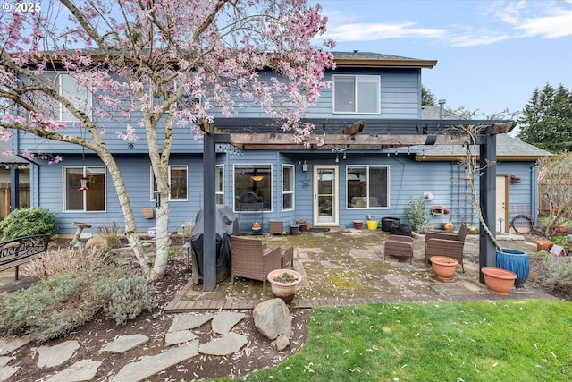 back of property with roof with shingles and a patio