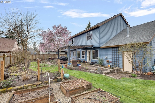 rear view of property featuring a garden, fence, roof with shingles, and a lawn
