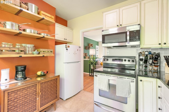 kitchen featuring stainless steel appliances, dark countertops, open shelves, and light tile patterned flooring