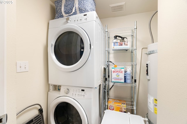 clothes washing area with stacked washer / drying machine and electric water heater