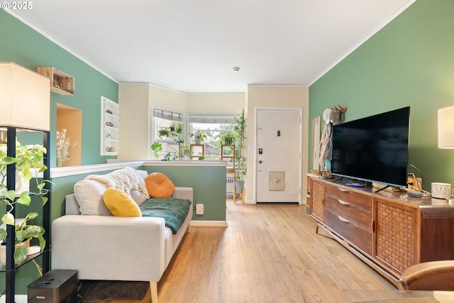 living room with crown molding and light wood-style floors