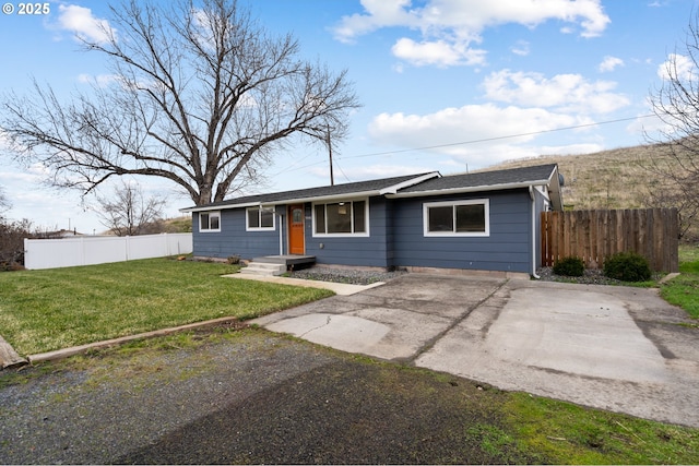 ranch-style house featuring a front yard and fence