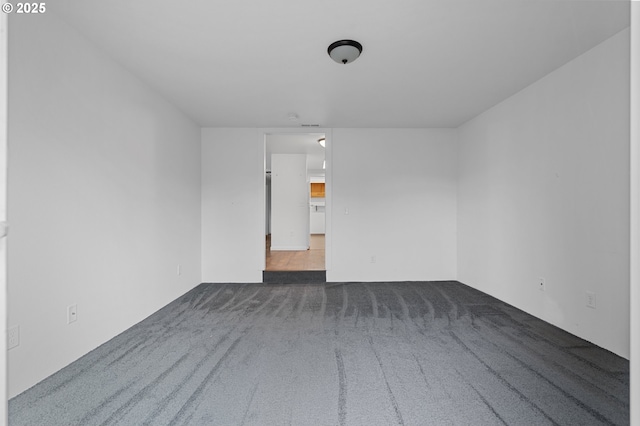 spare room with dark carpet