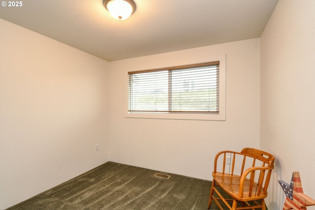 sitting room featuring visible vents and dark carpet