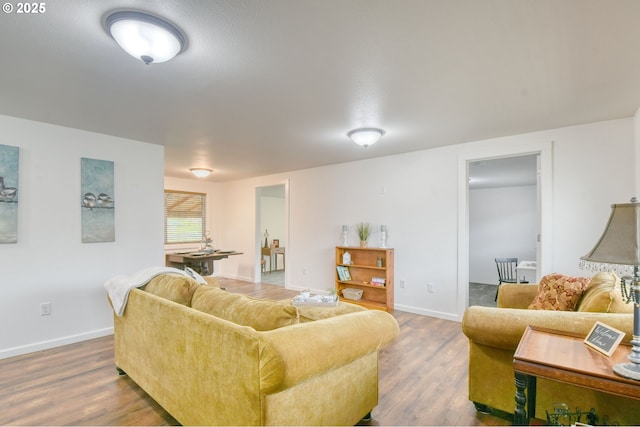 living area featuring baseboards and wood finished floors