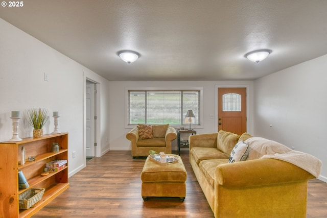 living room with a textured ceiling, baseboards, and dark wood-type flooring