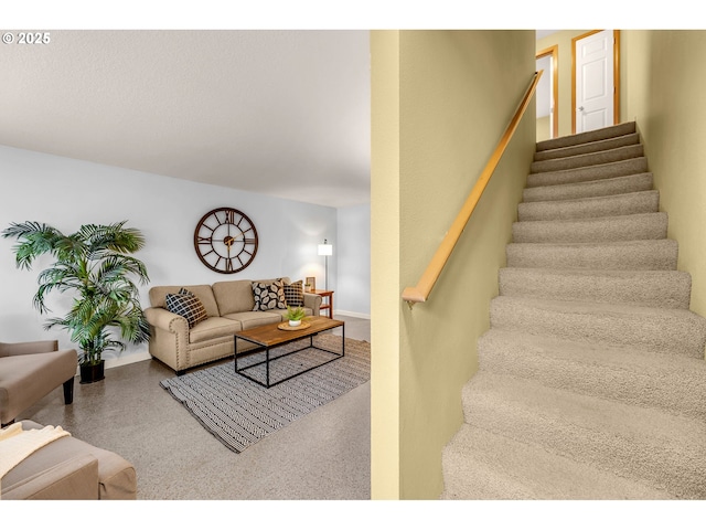 stairway featuring speckled floor and baseboards