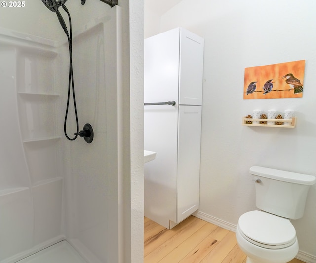 37459 Boulder Flat Ln, Halfway, OR 97834 - full bathroom featuring wood finished floors, a stall shower, baseboards, and toilet