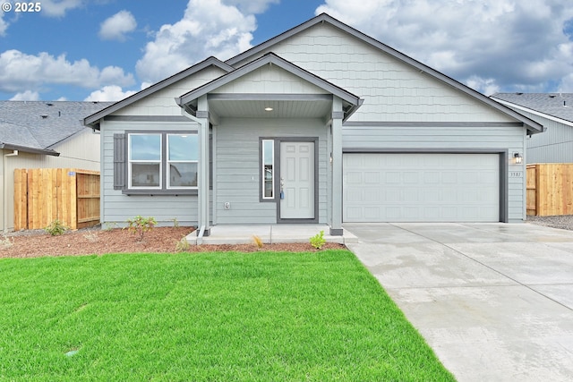 view of front of house with a garage, concrete driveway, a front lawn, and fence