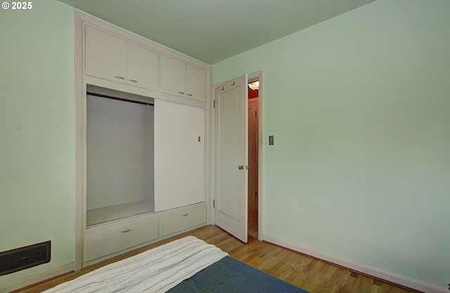 unfurnished bedroom featuring a closet and light hardwood / wood-style flooring