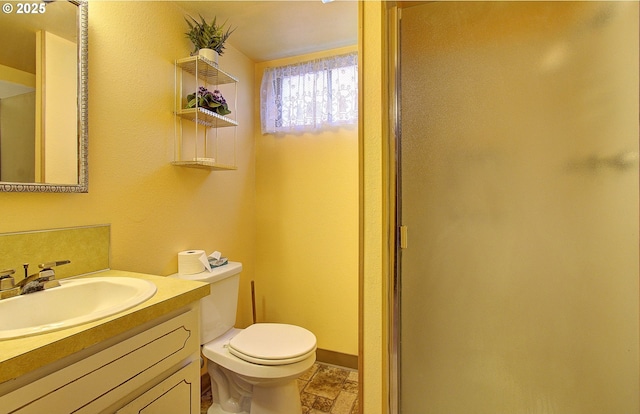 bathroom with vanity, walk in shower, and toilet